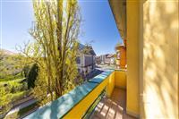 Balkon s dlažbou nabízí výhled na městskou krajinu. Světlý a prostorný venkovní prostor poskytuje ideální místo pro relaxaci.