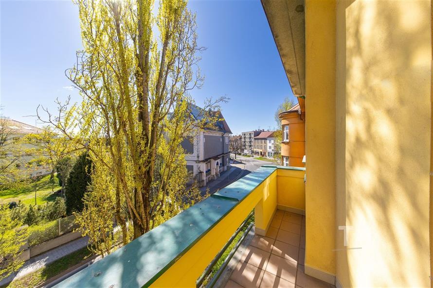 Balkon s dlažbou nabízí výhled na městskou krajinu. Světlý a prostorný venkovní prostor poskytuje ideální místo pro relaxaci.