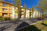 Exteriér bytového domu s historickými prvky, nová fasáda, klidná rezidenční čtvrť, udržovaná zeleň, výborná dostupnost do centra města.