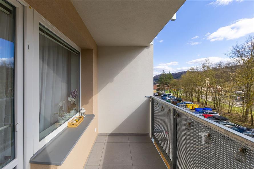 Prostorný balkon s dlažbou, moderní zábradlí, výhled do přírody, svěží vzduch a tiché okolí ideální pro relaxaci
