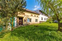 Tradiční dům s upravenou zahradou, fasáda v dobrém stavu, ideální na venkově, krásné okolí se vzrostlými stromy a klidné prostředí.