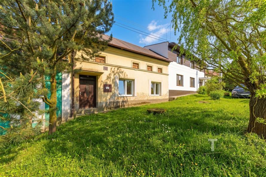 Tradiční dům s upravenou zahradou, fasáda v dobrém stavu, ideální na venkově, krásné okolí se vzrostlými stromy a klidné prostředí.