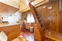 Dřevěný interiér se schody, dřevěné obložení stěn, vestavěné skříně, světlý prostor díky velkému oknu, rustikální styl.