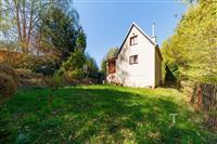 Zahrada u rodinného domu s trávníkem, lesní okolí, dřevěný plot, klidná lokalita.