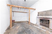 Rekonstruovaný pokoj s krbovými kamny a dřevěnými trámy, betonová podlaha, ideální pro úpravy dle vlastního stylu a vkusu.