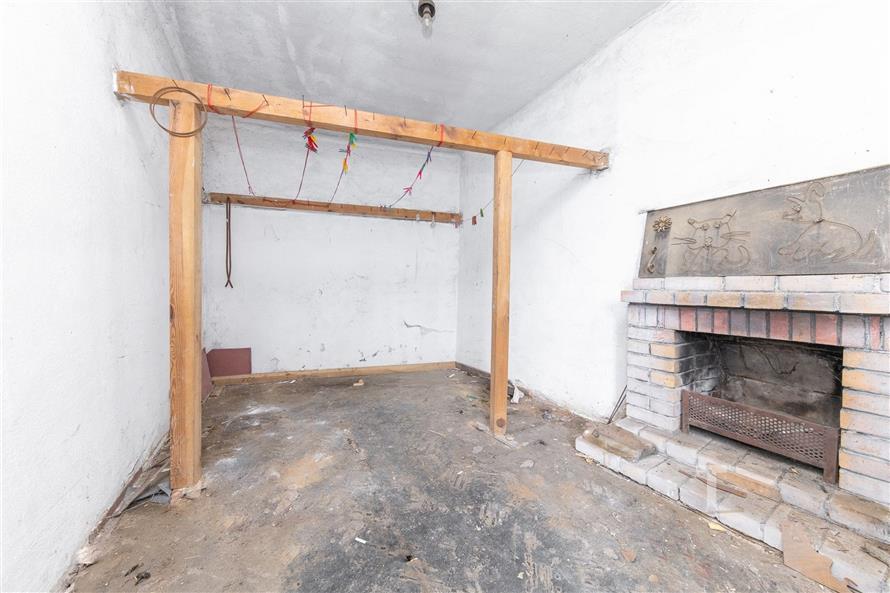 Rekonstruovaný pokoj s krbovými kamny a dřevěnými trámy, betonová podlaha, ideální pro úpravy dle vlastního stylu a vkusu.