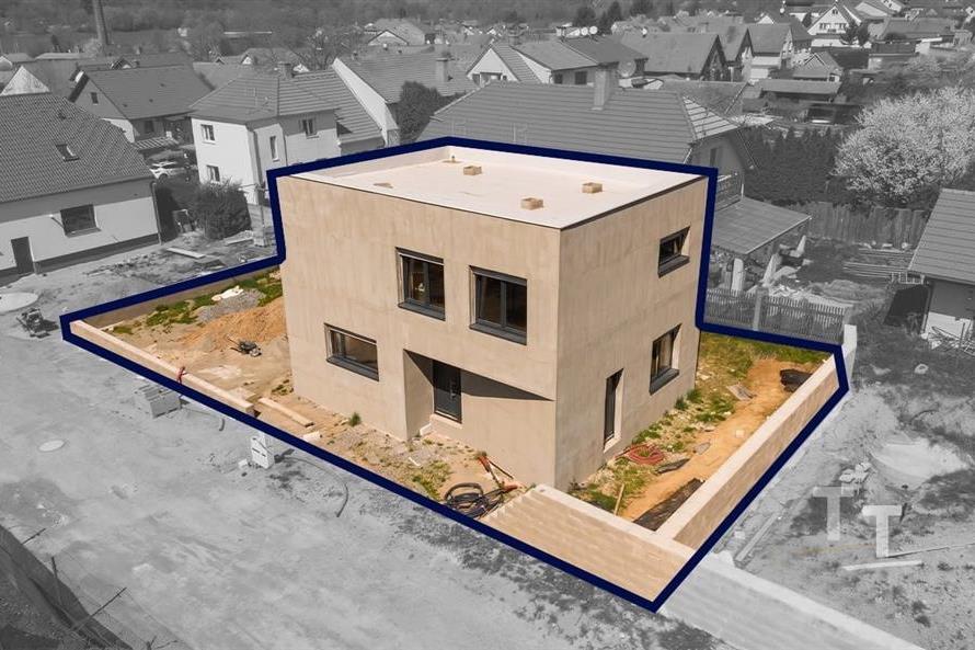 Moderní rodinný dům s dřevěnými obklady, velkými okny a novostavbou, umístěný v klidné rezidenční čtvrti s novými domy.