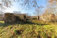 Rozlehlý stavební pozemek s částečně zbořenými kamennými zdmi, ideální pro rekonstrukci nebo novou stavbu, klidná lokalita.