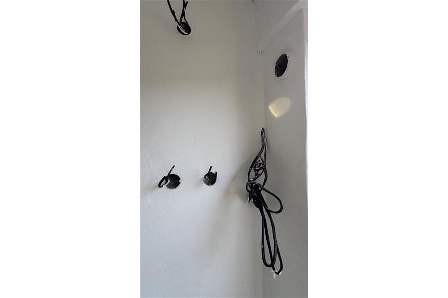 Prázdná místnost s přípravou na elektroinstalaci, bílé stěny, moderní budova, ideální pro rekonstrukci nebo přestavbu.